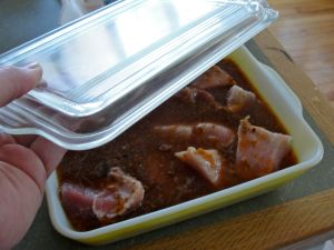 Cover the pork with fat, and water mixture, in a covered dish in preparation for moist cooking phase.