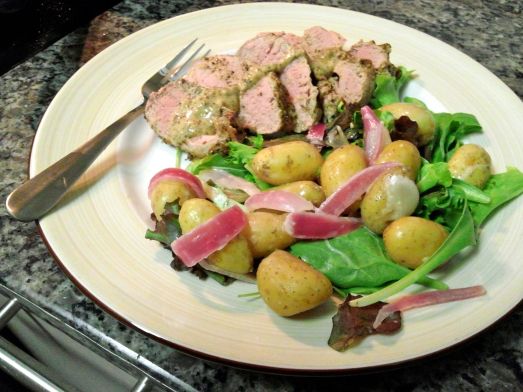 Mustard and Black Pepper Pork Loin with a salad of mixed greens, fingerling potatoes and blanched red onion.