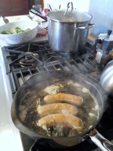 Boiling fresh Italian sausage and steaming red potato.