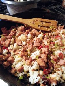 Stir frying the ham, garlic, spring onion, red pepper, and rice.